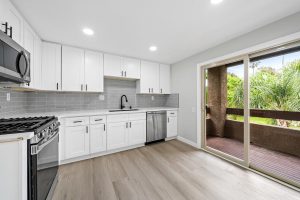 updated kitchen with white cabinets, stainless appliances and black faucet