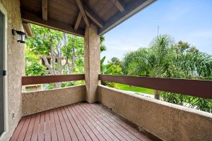 covered balcony with lush landscaping