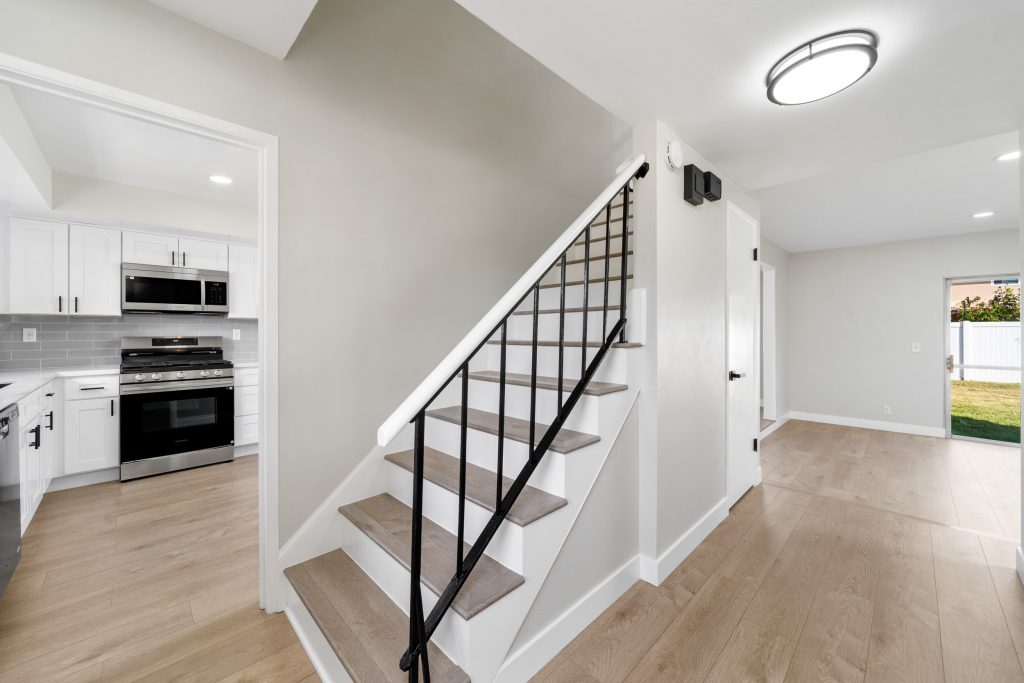 staircase leading upstairs with neutral colored hardwood flooring