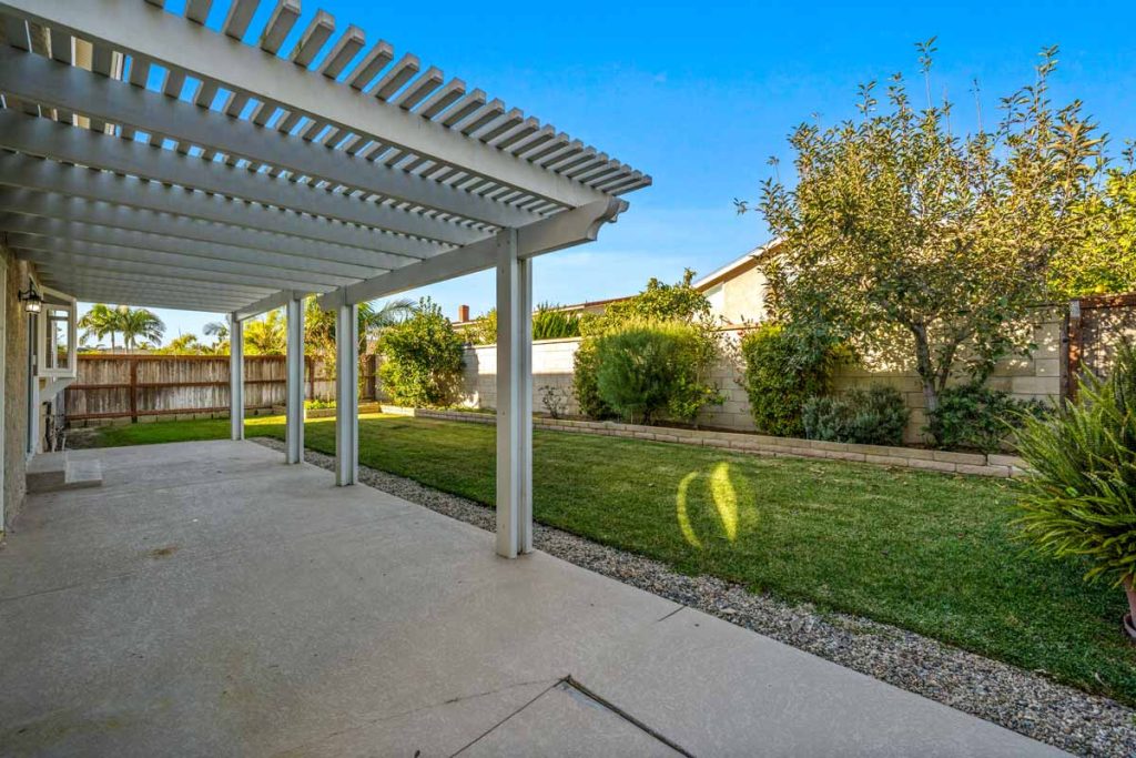 backyard of home showing covered patio and grass