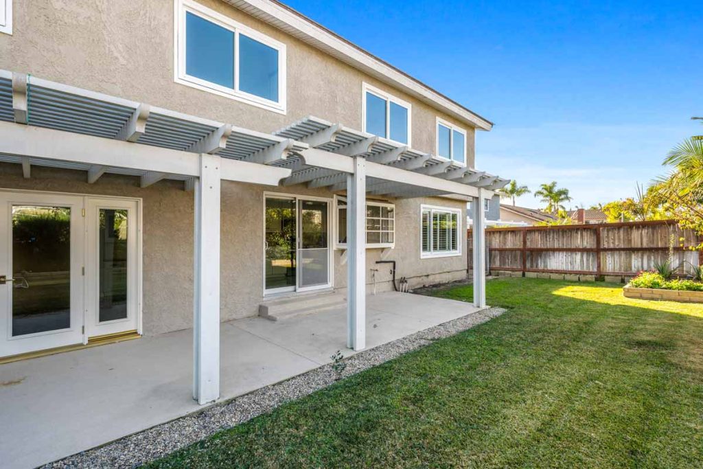 backyard of home showing house, covered patio and grass