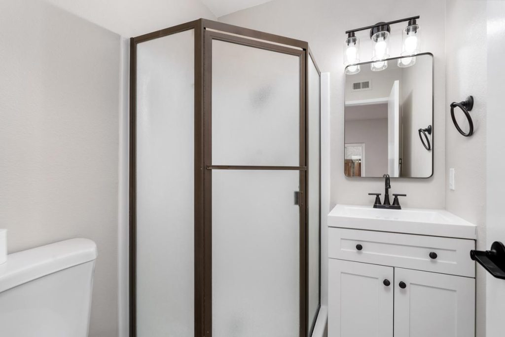 3/4 bathroom with white vanity and stand-up shower stall