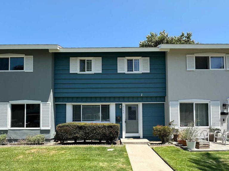 image of exterior front of home for sale showing a a dark teal paint with white trim