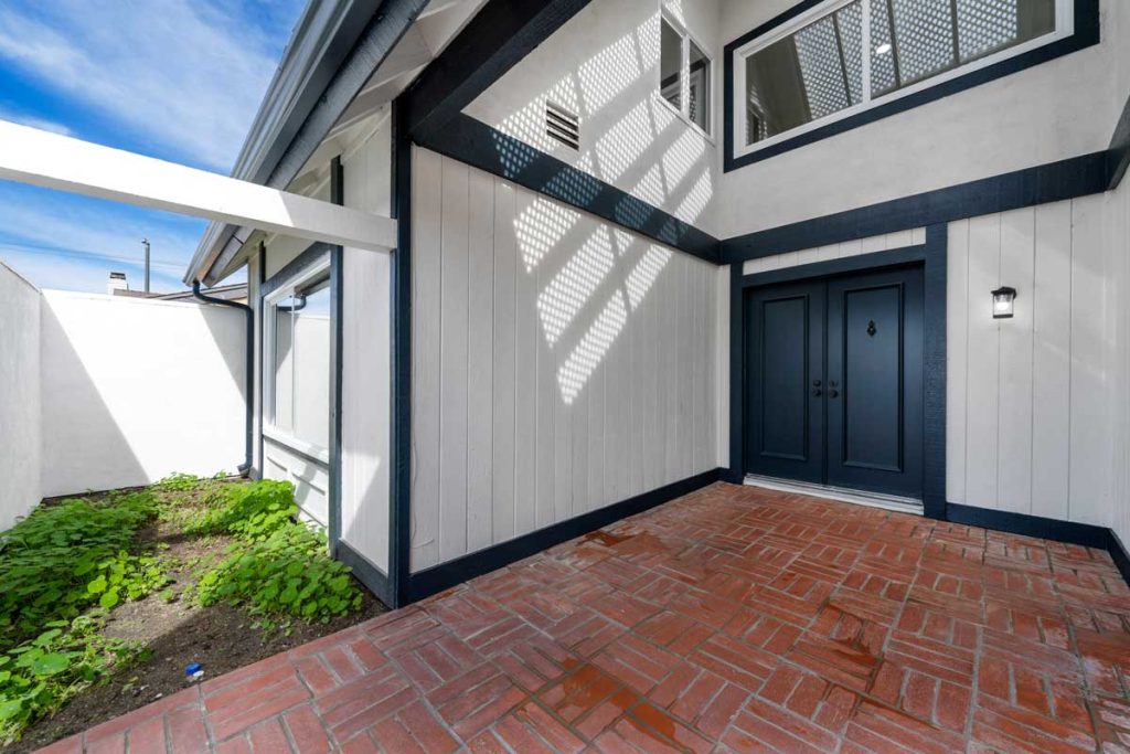 exterior entry way into white home with blue trim and blue double doors