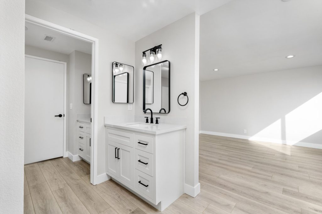 updated bathroom with white cabinet and black accents