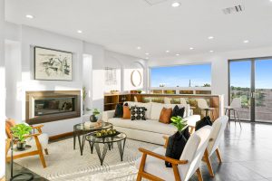 couch and fireplace with bar and wall of ocean-view windows in background
