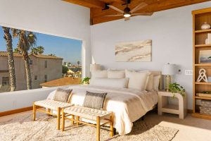 bedroom with large window and neutral bed