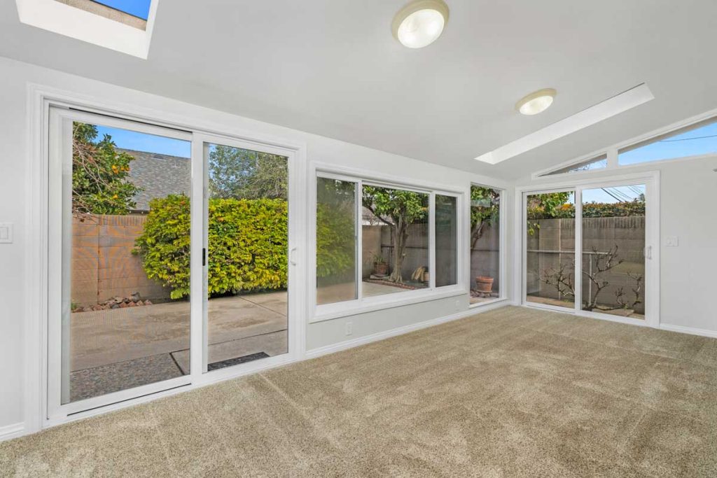 addition off of the kitchen with a wall of windows overlooking the backyard.