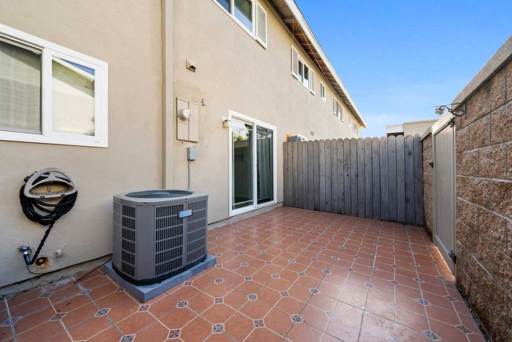 yard space showing tile floor, a/c unit and fence with gate