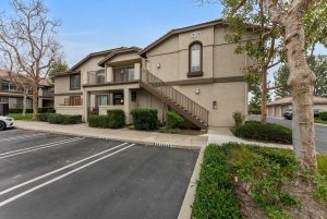 exterior of townhouse with parking spaces and staircase to front door