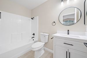 updated bathroom with white cabinets and black fixtures