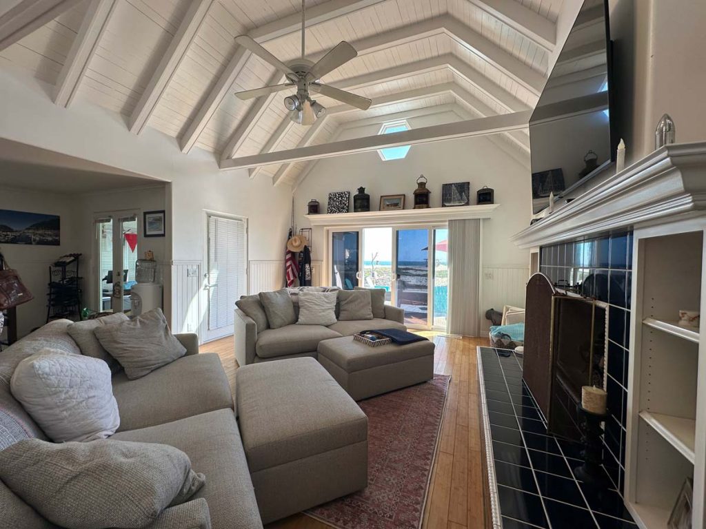 large and enclosed beachfront sunroom, gray couch and white ceilings