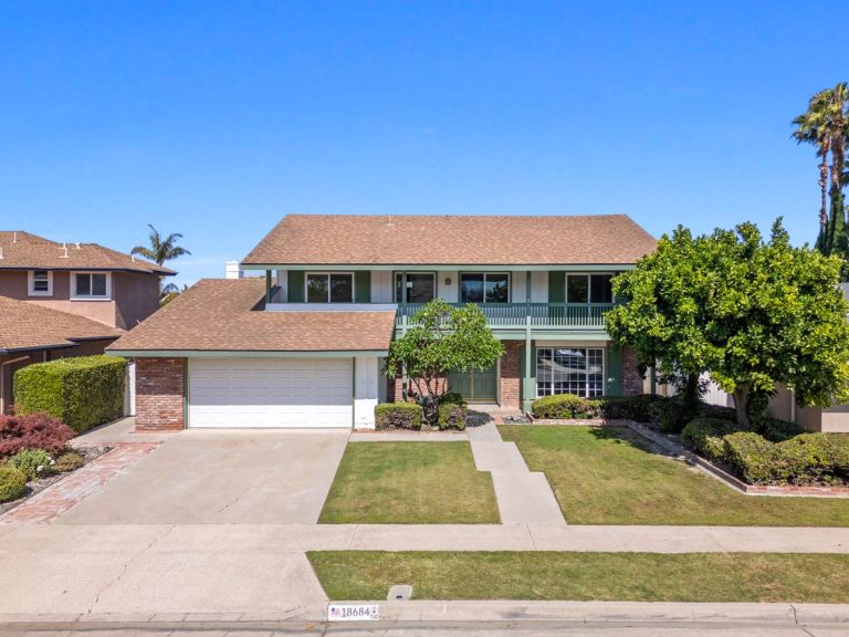street view of two story home with white garage door and tan roof