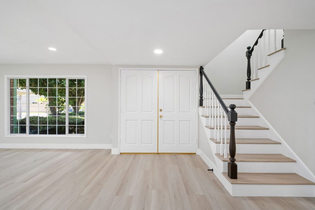 interior view of front door and staircase with neutral floors and walls