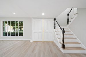 interior view of front door and staircase with neutral floors and walls
