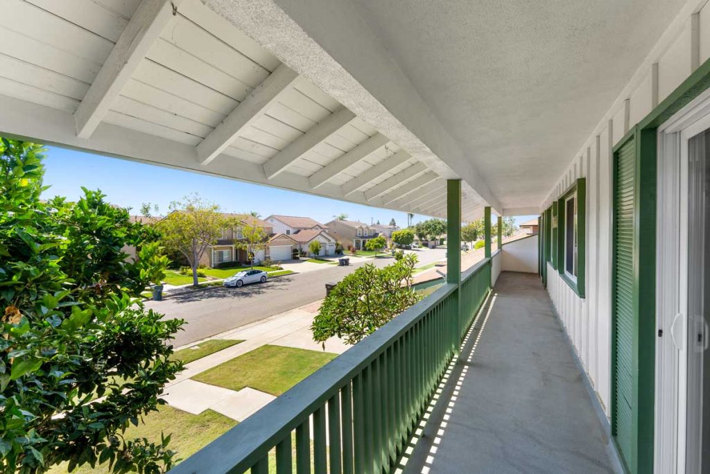 second level deck off front of house with view of street below