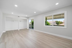 large empty bedroom with window and door leading to balcony