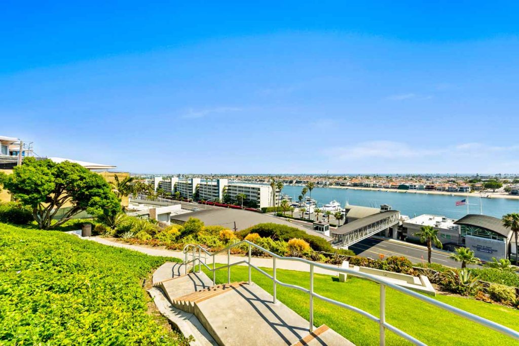 walking path with steps leading down towards a street and water in the harbor