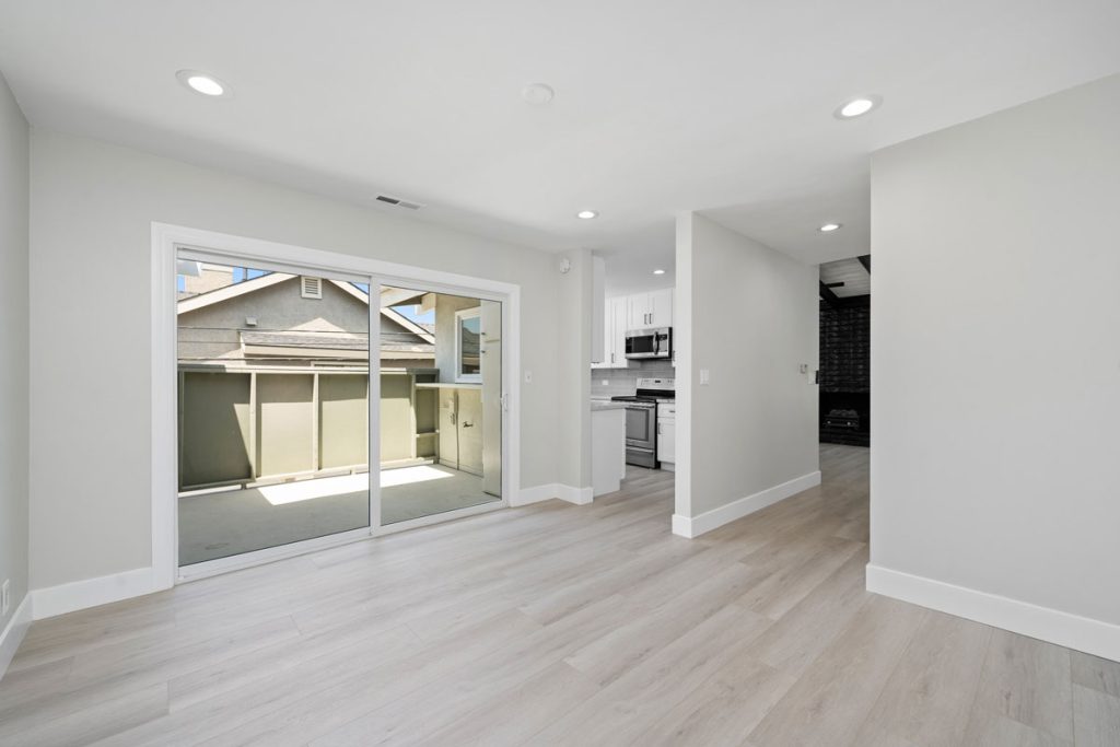 empty dining room with sliding doors to balcony and view of kitchen