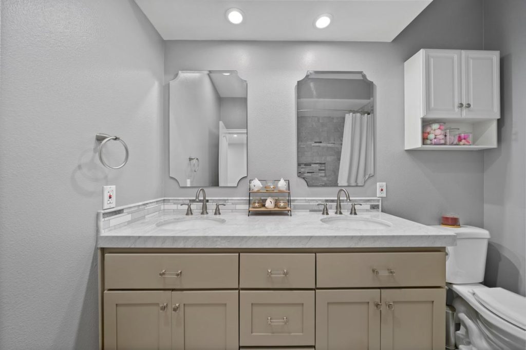 dual vanity with mirrors and toilet to the side
