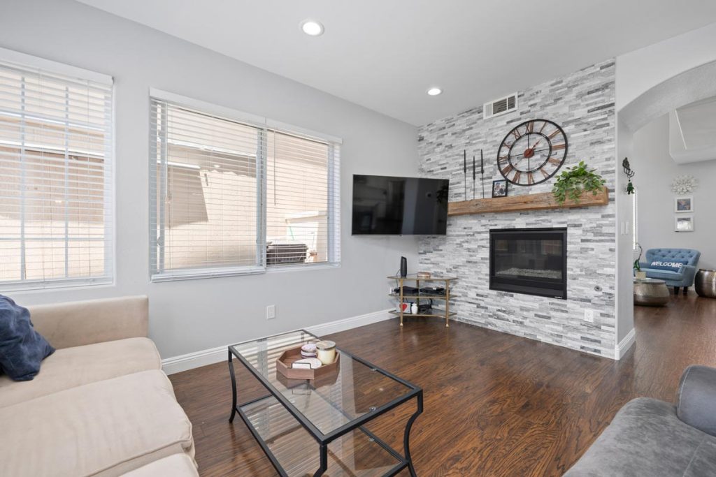 living room with couch, hardwood floors, fireplace and mounted tv