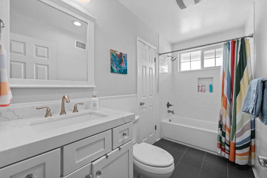 full bathroom with white vanity, toilet and tub/shower combo