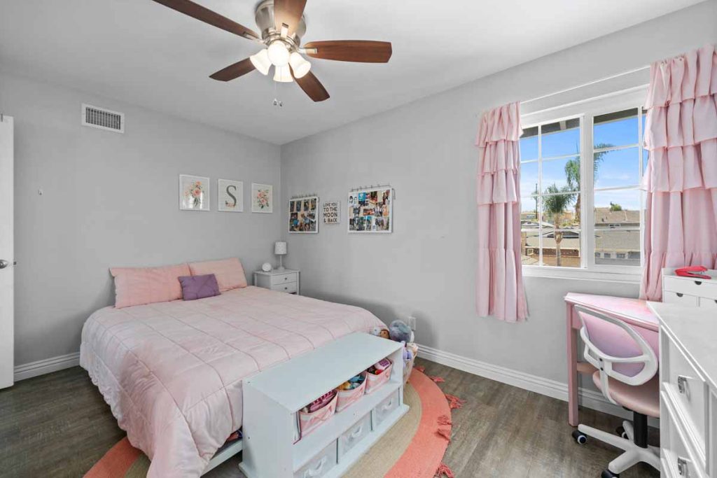 bedroom with pink bedding and window coverings