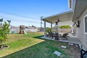 backyard showing grass, covered patio and play structure