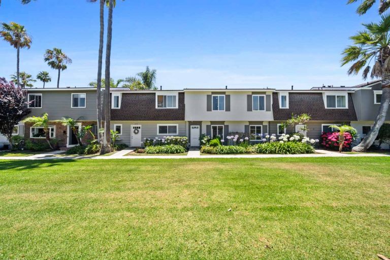 view of the front of 8125 Ridgefield Drive, Huntington Beach from across a large grassy area