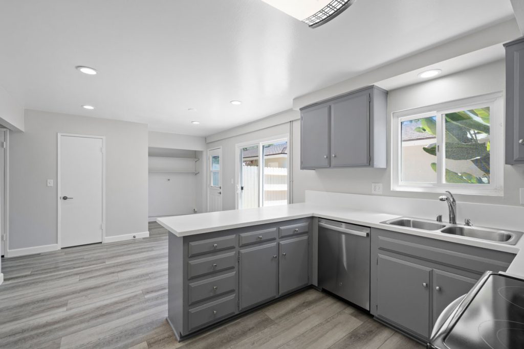 neutral updated kitchen with white stone countertops and gray cabinets