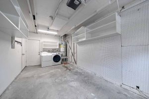 empty garage with shelves and a washer and dryer.