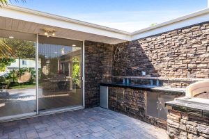 outdoor kitchen including mini fridge, sink and barbecue.