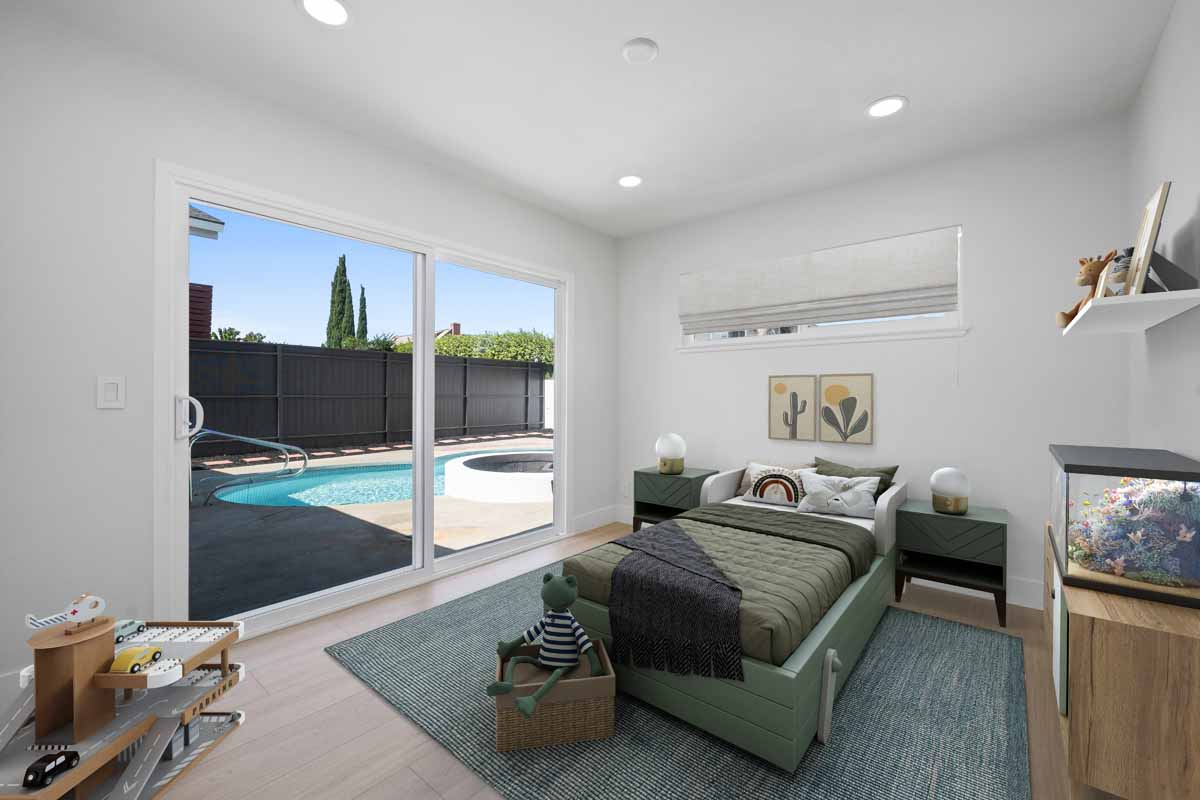 A staged bedroom showing a bed and nightstands and with a sliding glass door leading to the backyard and pool