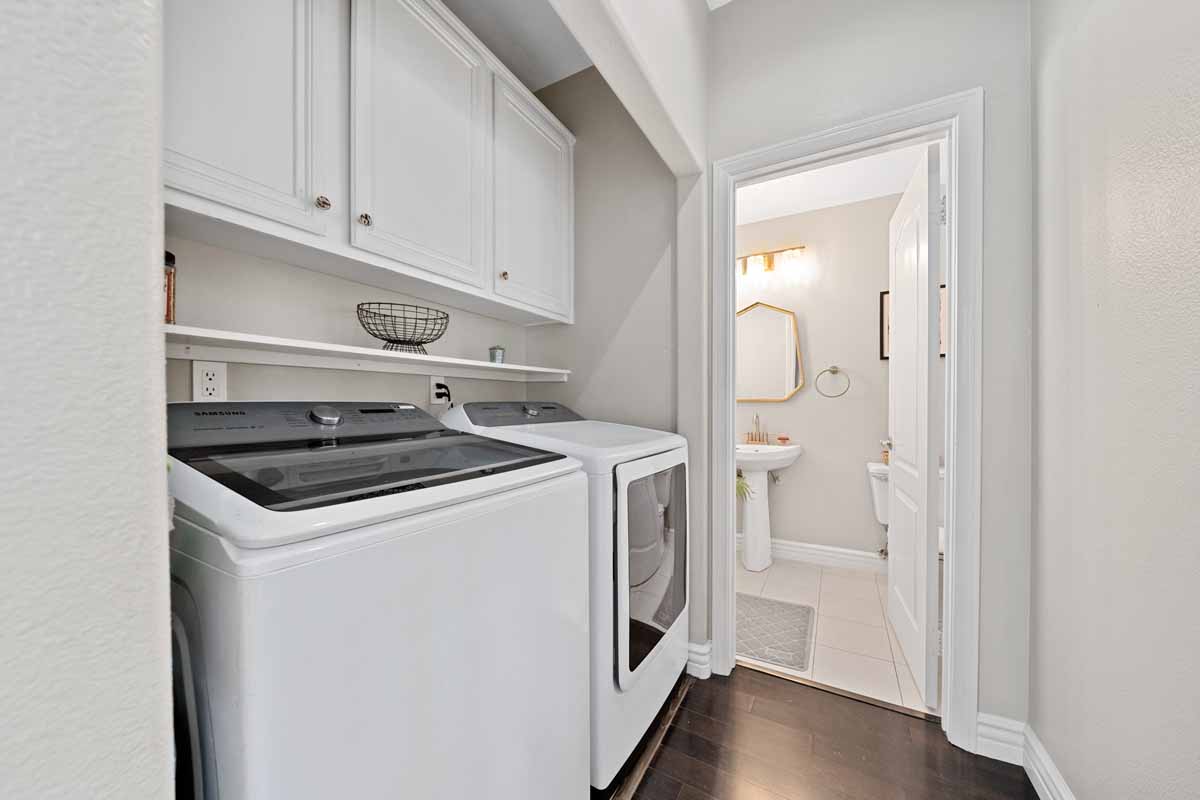 Hall way with laundry area leading up to a bathroom.