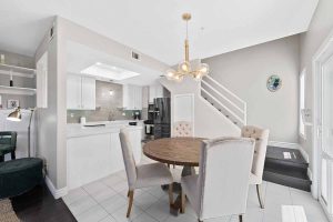 Dining table off the kitchen showing stairway leading up in the background.