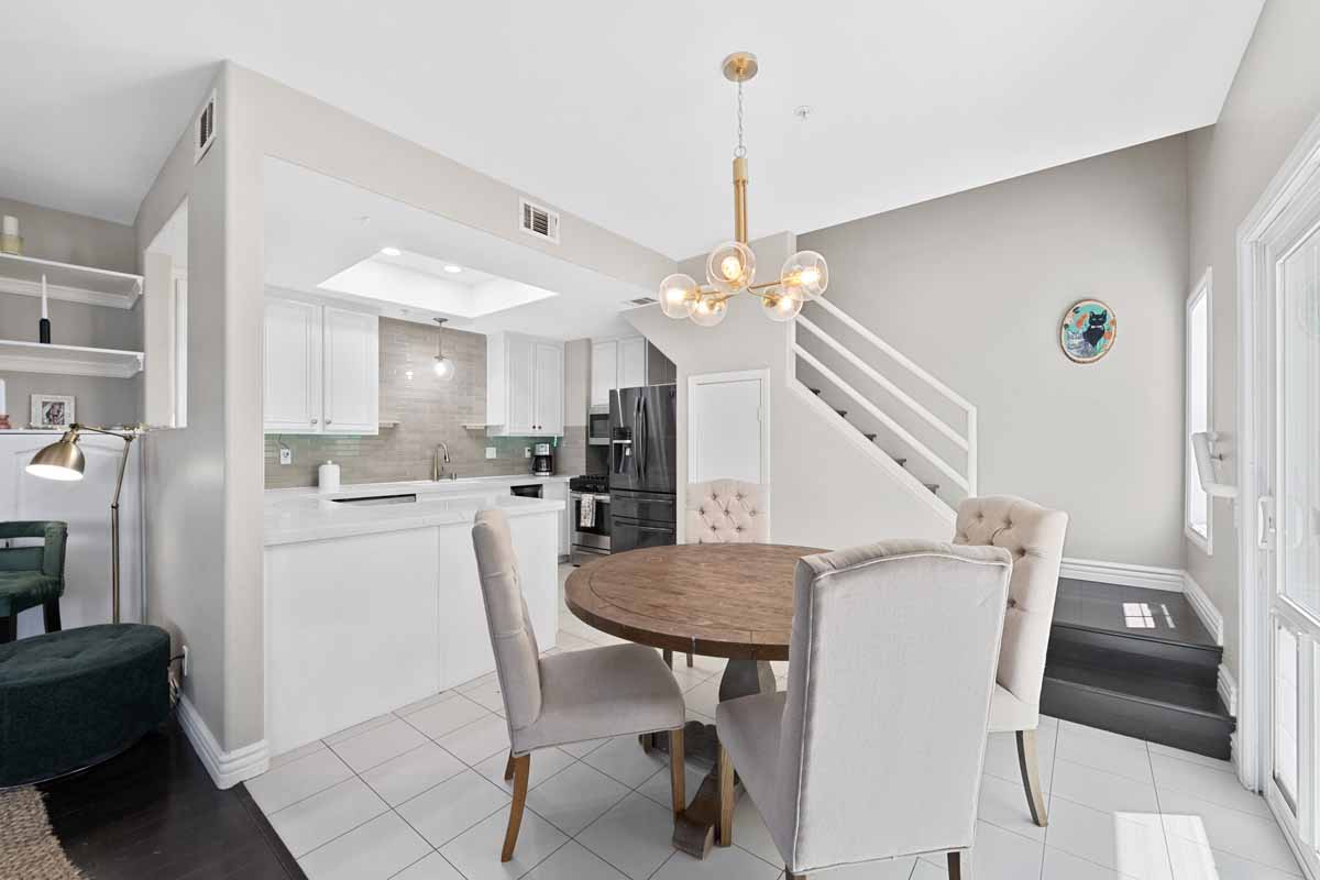 Dining table off the kitchen showing stairway leading up in the background.
