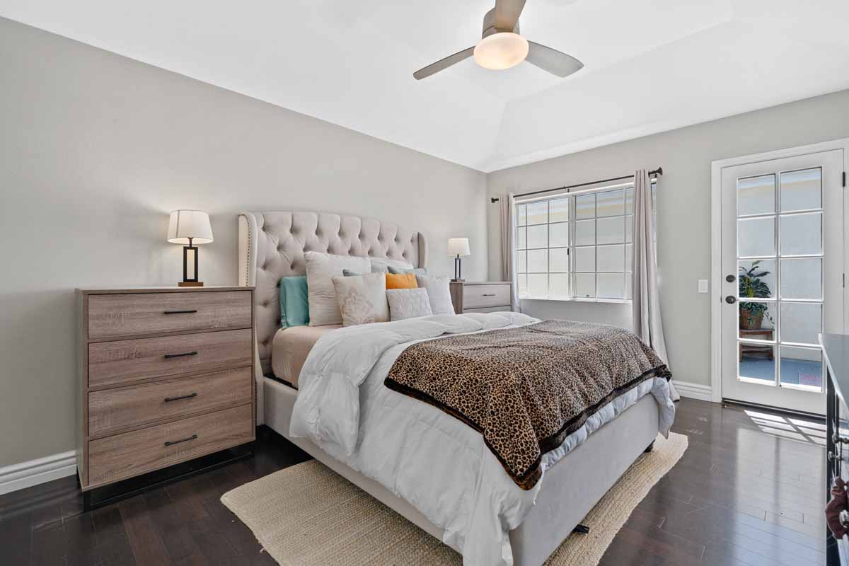 Master bedroom with a large bed that has a fabric headboard.