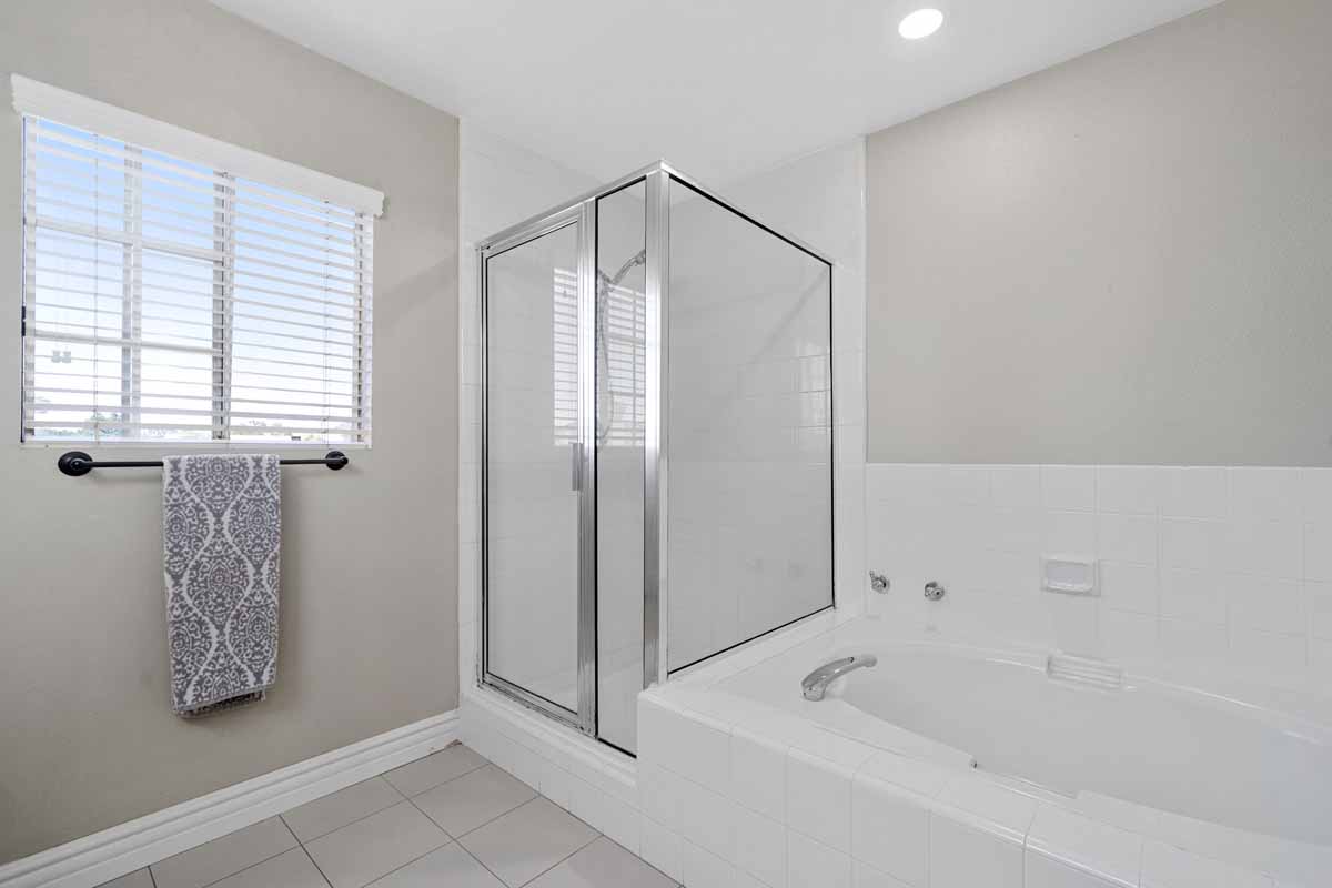 Neutral clean master bathroom showing stand alone shower and separate bathtub.