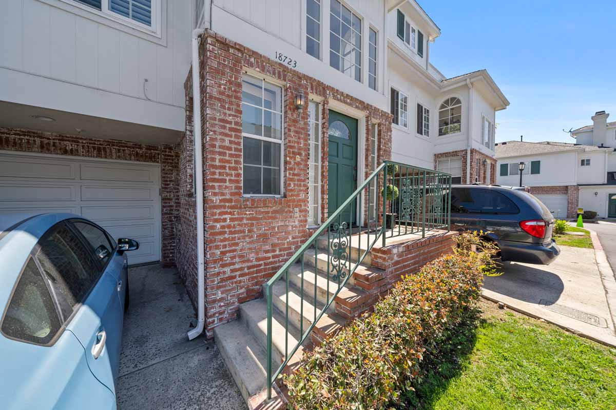 Exterior front entry way showing steps that lead to a teal front door.