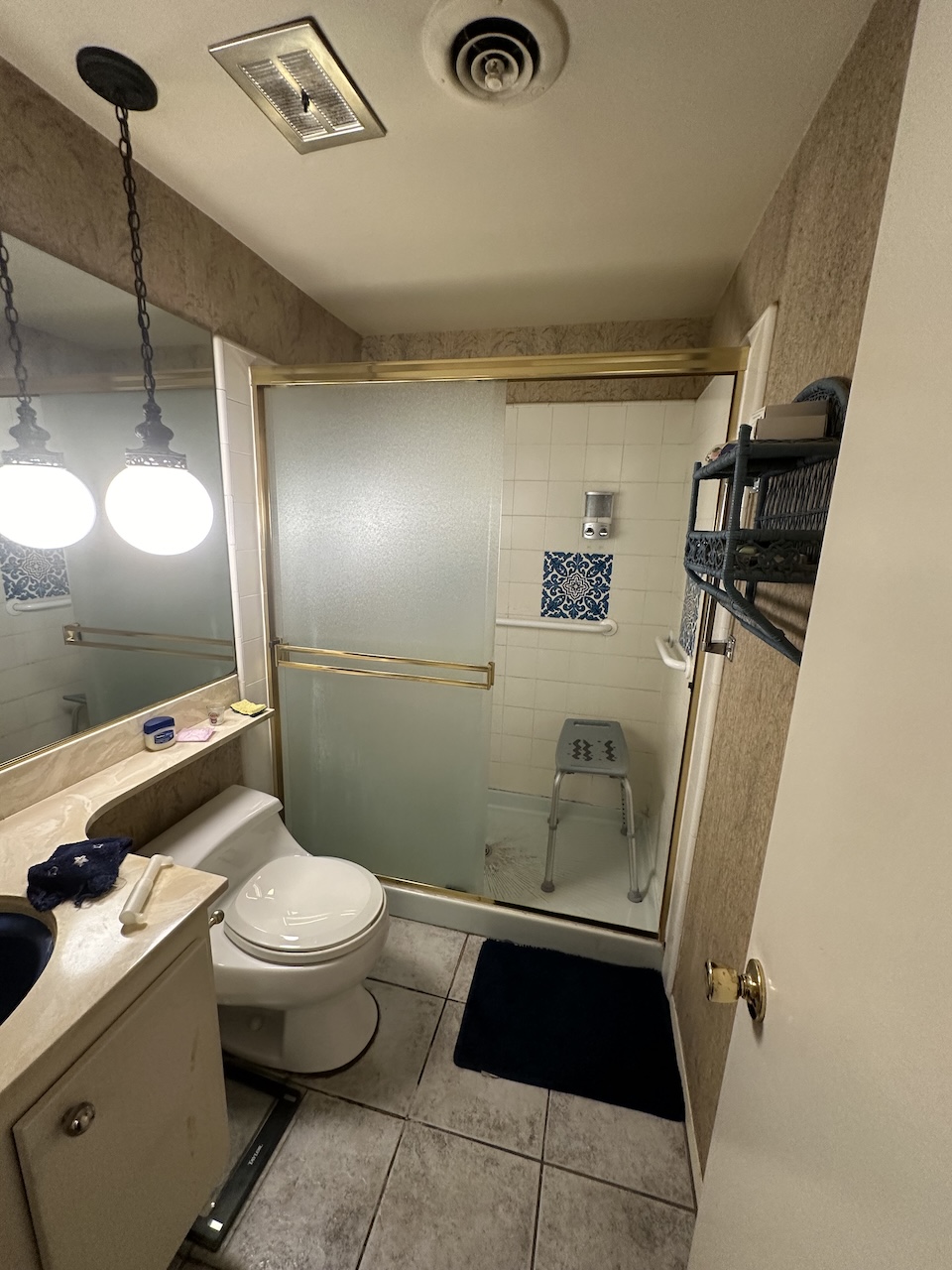 Before photo of an older bathroom with a shower. 