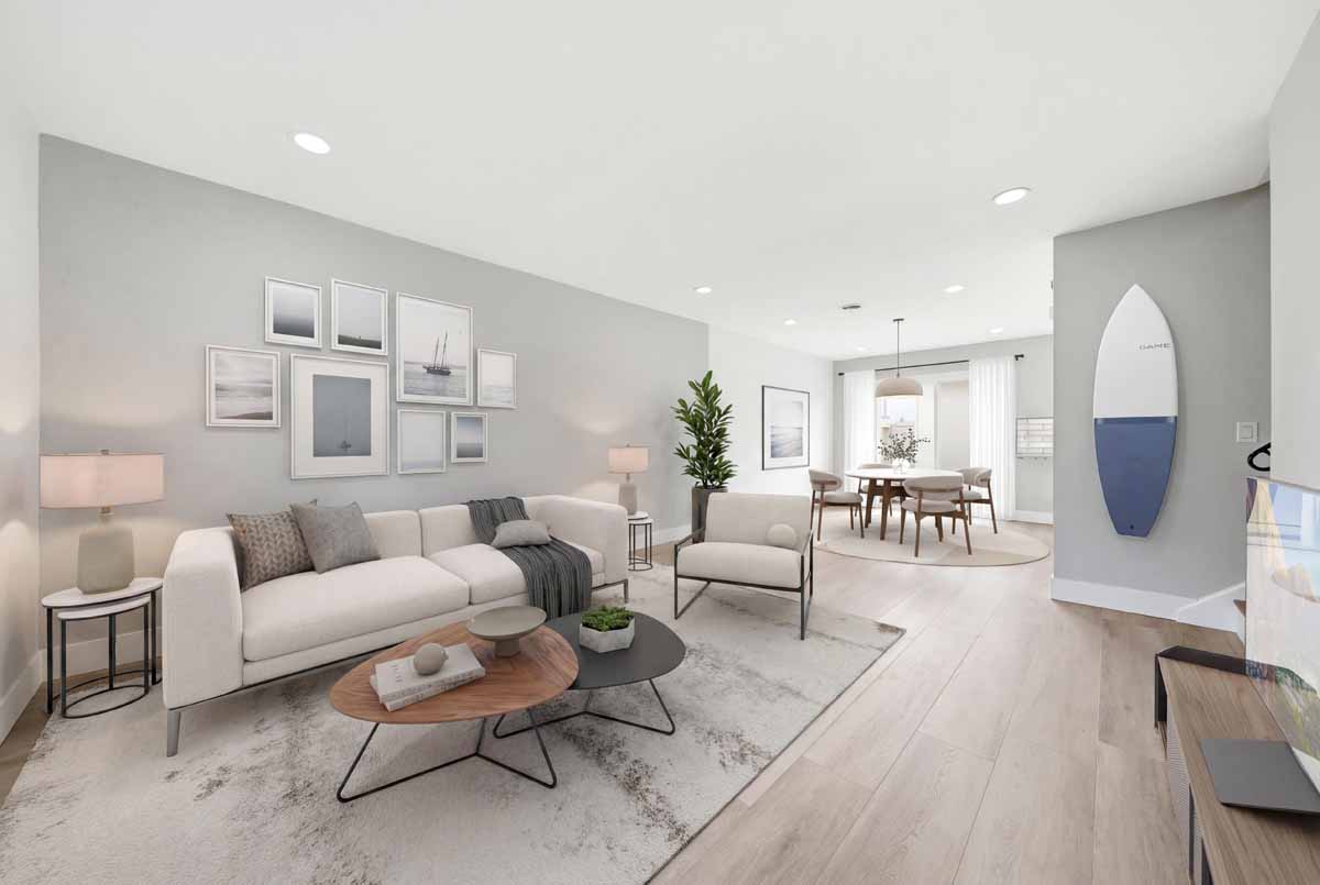 Digitally staged living space with couch, chair, coffee table and a dining table in the background.