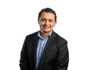 Justin DeCaro from Danny Murphy & Associates and JD Construction in a relaxed suit with a white background.