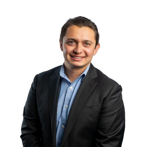 Justin DeCaro from Danny Murphy & Associates and JD Construction in a relaxed suit with a white background.