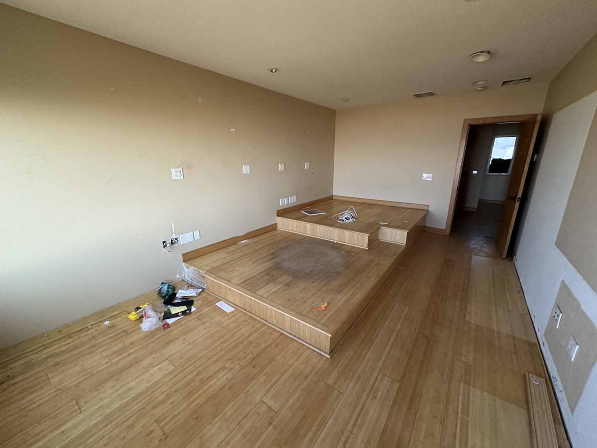 A bedroom with wood floors in the middle of being renovated.