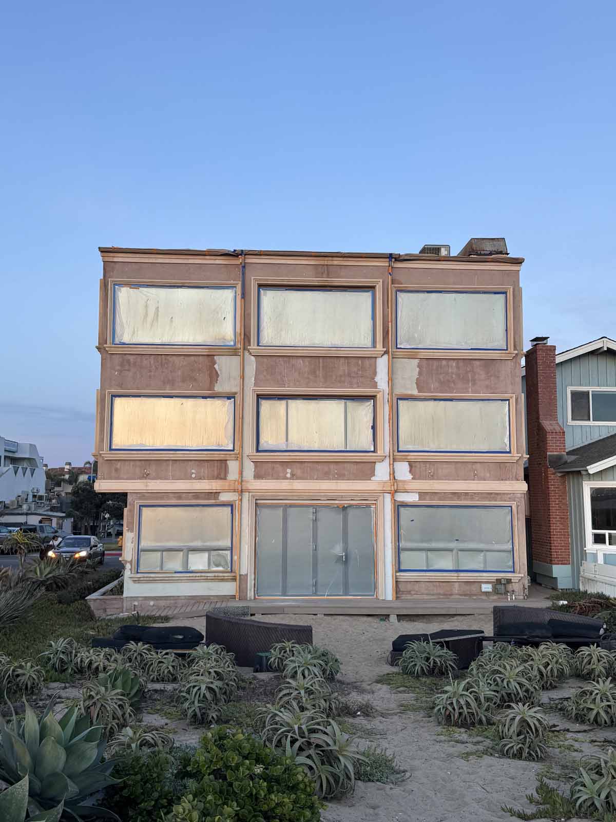 Rear exterior of beach front home with large windows covering the entire back side.