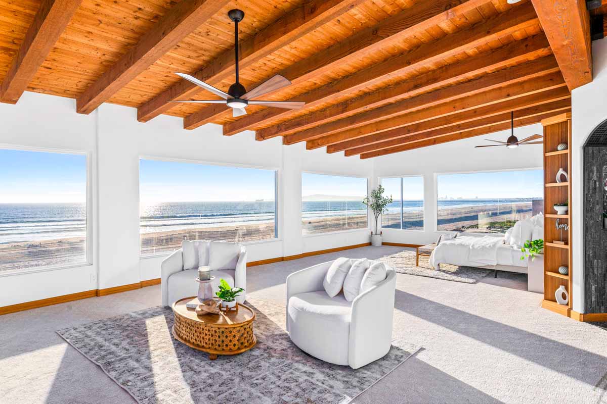 Updated master bedroom with wood beamed ceiling, a wall of windows overlooking the beach and nice, neutral furniture.