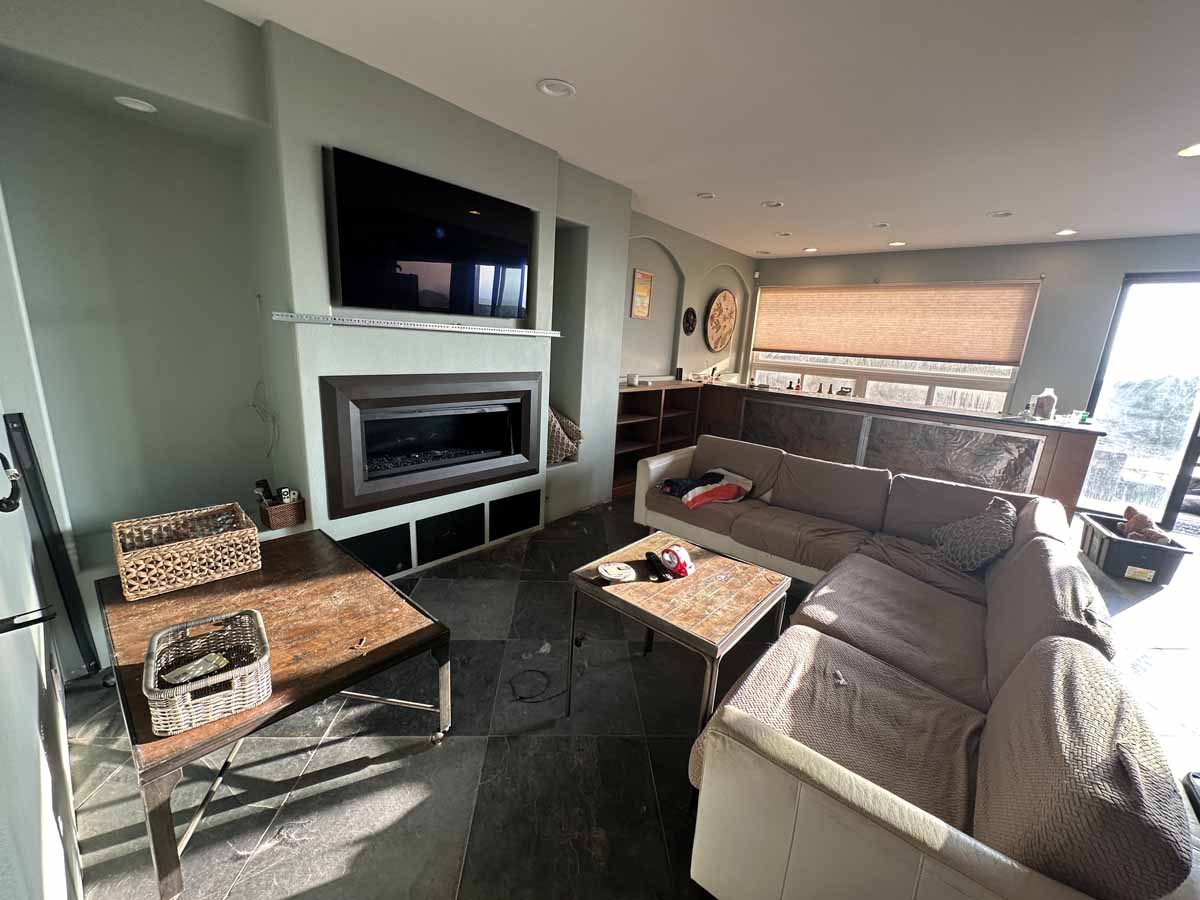 Living space showing a couch, fireplace and mounted television.