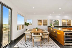 Updated dining and kitchen space with a door leading to the patio on the beach.