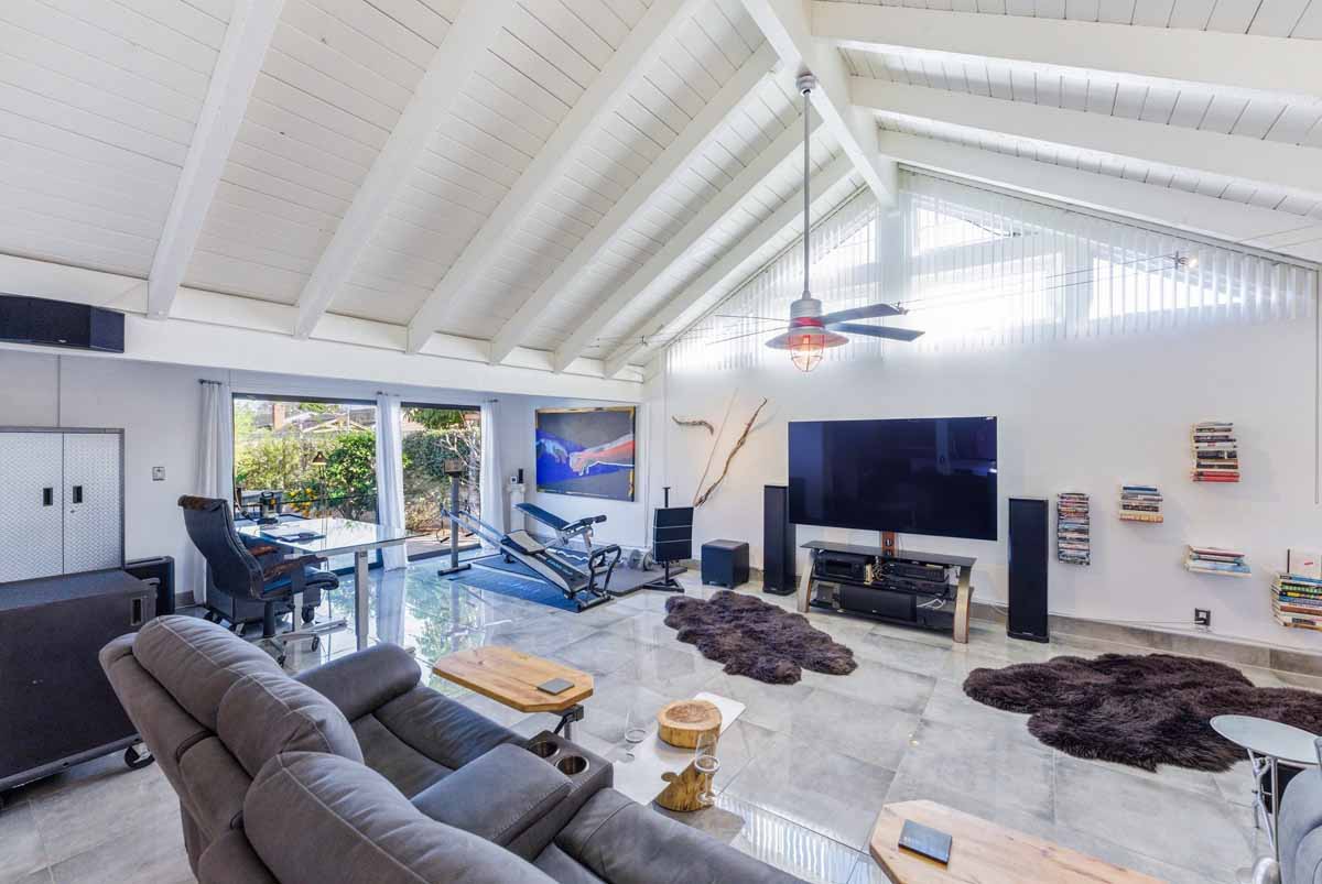 Living room with wood beams on a vaulted ceiling.