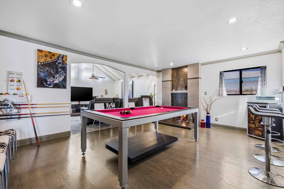 Family room with wood flooring and a pool table.